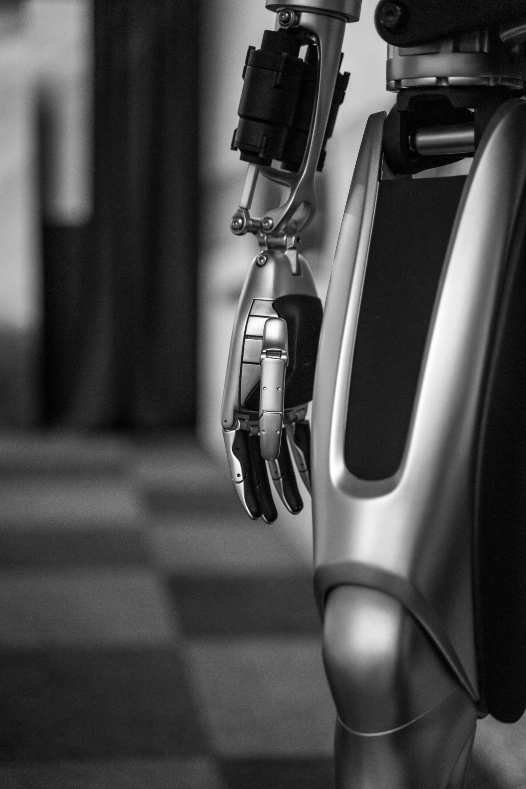 Detailed black and white shot of a futuristic metallic robot arm, showcasing advanced technology.